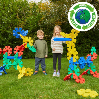 Kinderen bouwen samen met kleurrijke Octoplay-schijven en palen op een grasveld tijdens hun vakantie op de camping. Kinderen bouwen samen met kleurrijke Octoplay-schijven en palen op een grasveld tijdens hun vakantie op de camping.